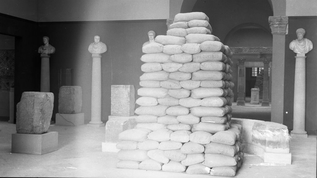 Interior del Museu d&rsquo;Arqueologia de Catalunya amb els sacs de terra protegint l&rsquo;escultura de la sala d&rsquo;Inscripcions commemoratives. Foto Ram&iacute;rez Sagarra (atrib) (MAC.AHF)