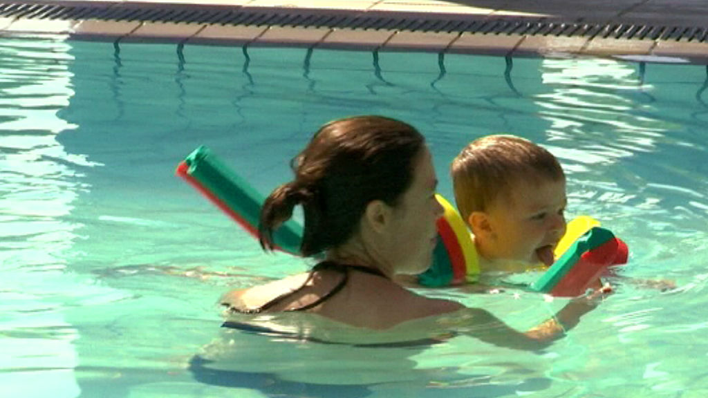 Mare i fill banyant-se en una piscina a l'estiu