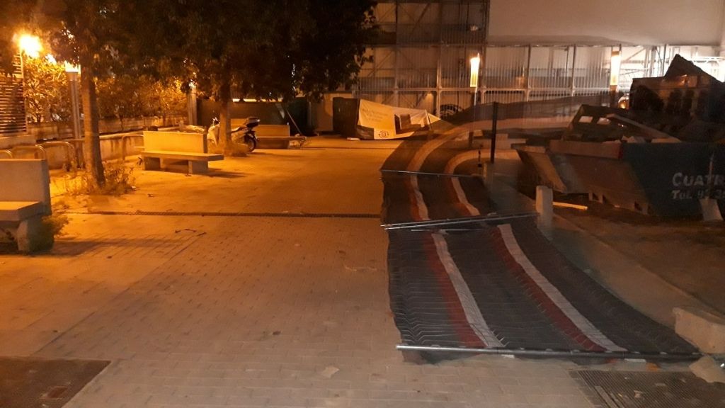 una tanca d'una obra caiguda a terra ple vent