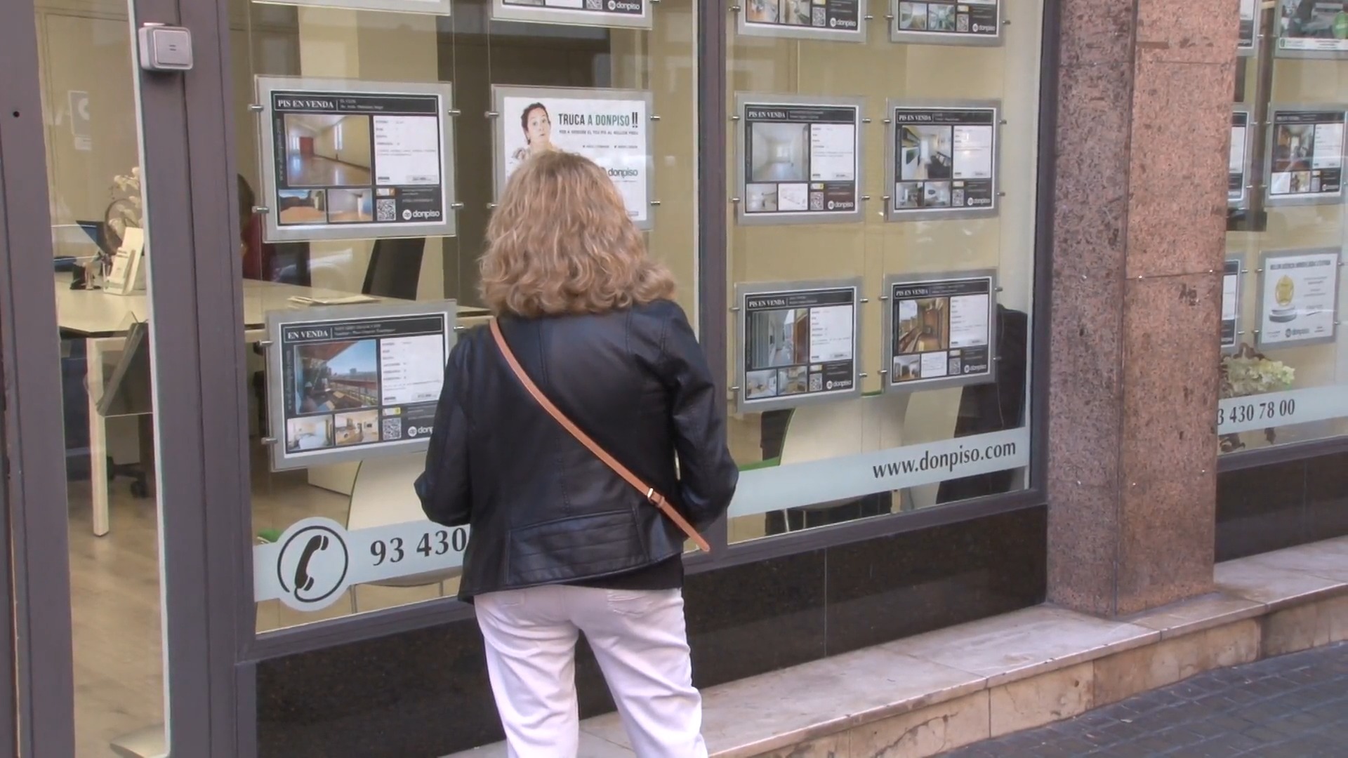 Una persona mira l'aparador d'una immobiliària