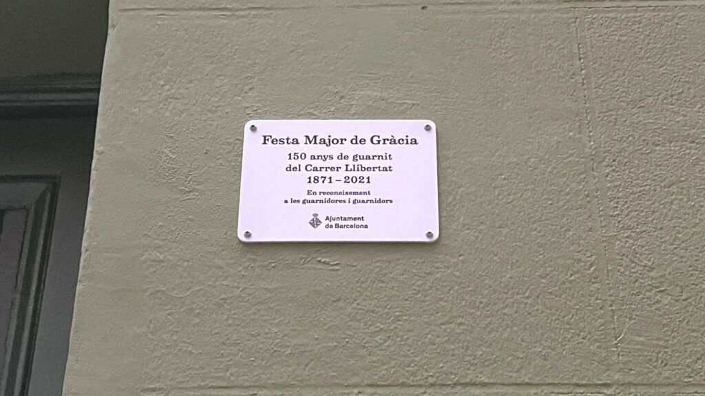 El carrer de la Llibertat destapa una placa en homenatge als 150 anys de la Festa Major de Gràcia | Festa Major de Gràcia, guarniments, tradicions