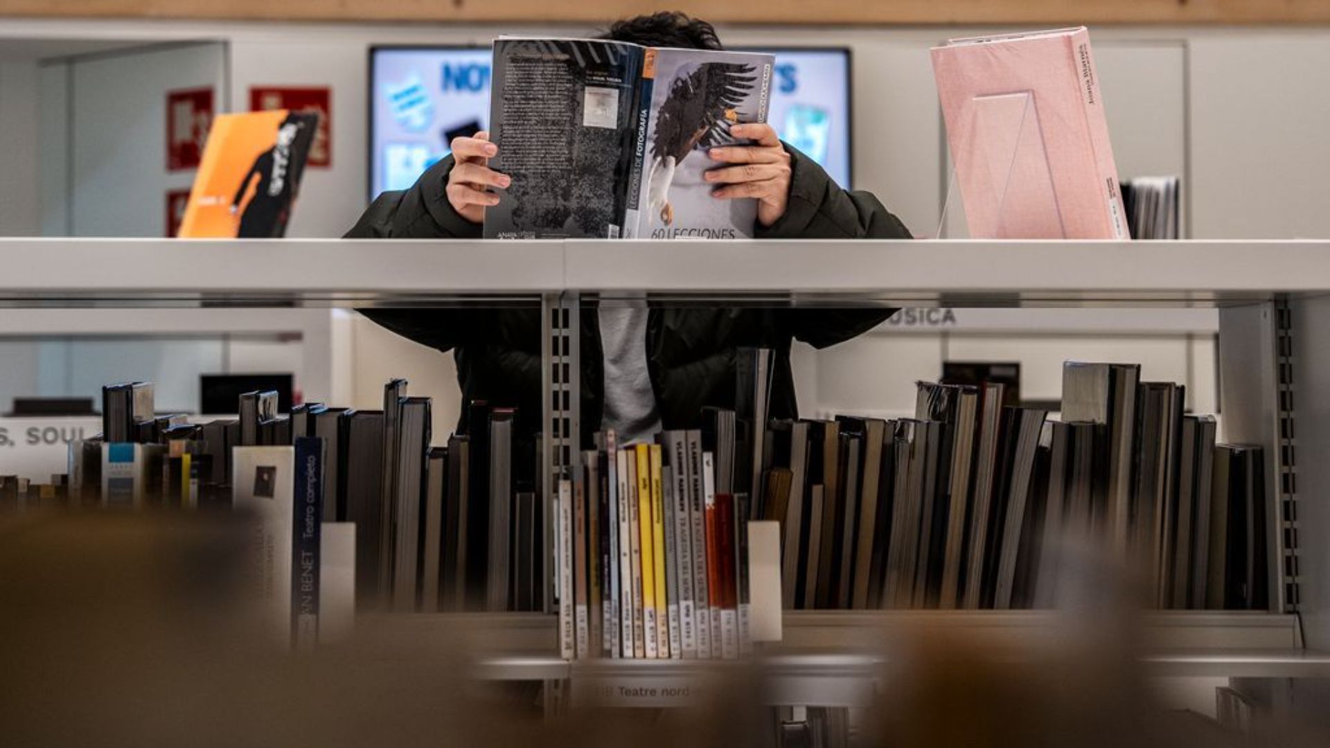una persona consulta un llibre a la Biblioteca García Márquez
