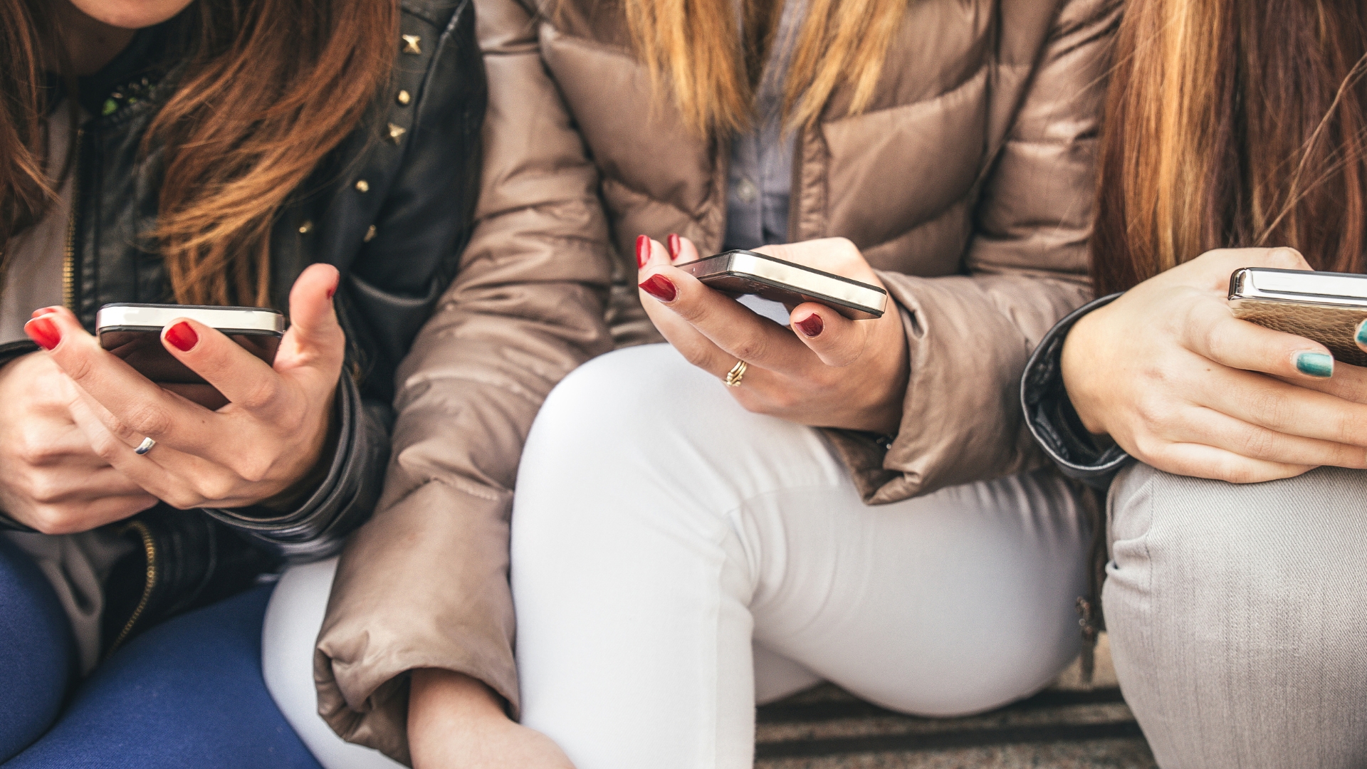 noies mirant el mòbil
